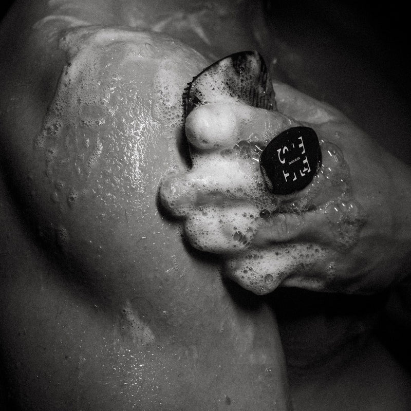 Person using TEST Body Scrubber on shoulder