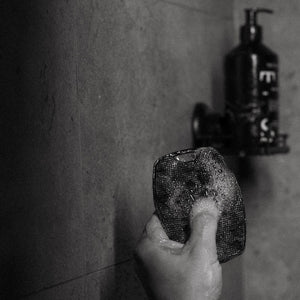Hand holding a TEST Body Scrubber