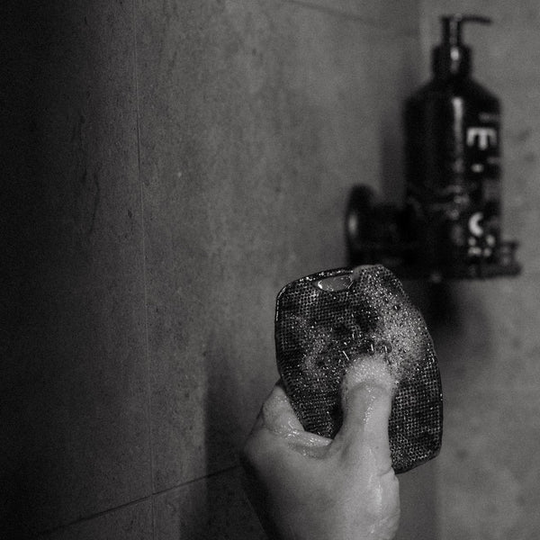 Hand holding a TEST Body Scrubber