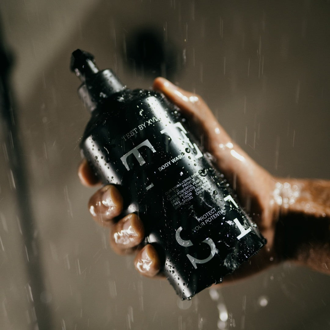 Holding TEST BODY WASH in the shower